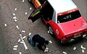 A man picks up money spilled by a security van in Wan Chai on December 24. More than HK$7 million is still missing. Photo: SCMP Pictures