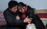 Parents like Cai Lijiao, crying in her husband’s arms. Their daughter was stolen as she slept when she was little over three months old. 