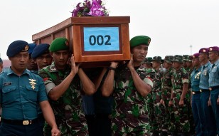 Indonesian military forces carry a victim's coffin. Photo: AFP