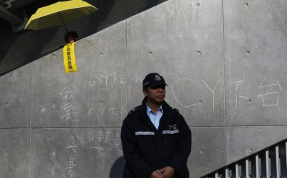 A police officer prevents further chalk graffiti.Photo: Sam Tsang