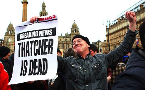 A man raises his arms in the air as he attends a gathering of people celebrating the death of former British Prime Minister Margaret Thatcher, in George Square, Glasgow, Scotland. Photo: Reuters