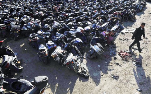Motorcycles and electric bicycles impounded by police from their owners after causing traffic accidents crowd a parking lot in Hefei, Anhui province. Photo: Reuters