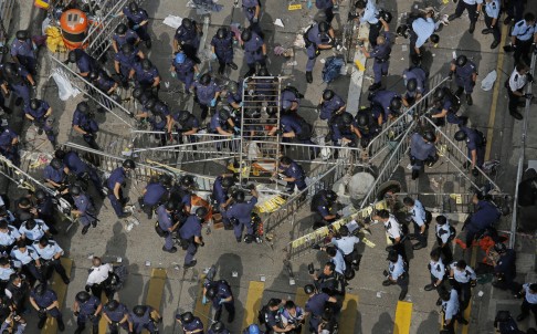 Police officers clearing the barricades in the Mong Kok occupied area last month. Photo: AP
