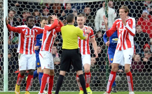 Stoke City players appeal to referee Michael Oliver for handball against United defender Chris Smalling. Photos: AFP 
