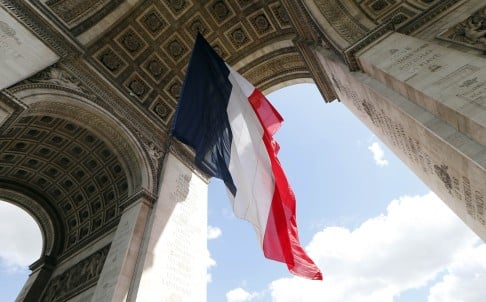 A French flag hangs under the Arc de Triomphe monument in Paris in preparation for Europe Day celebrations. Photo: AFP