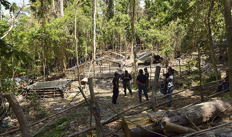 Thai police dig up 26 bodies at suspected jungle trafficking camp.