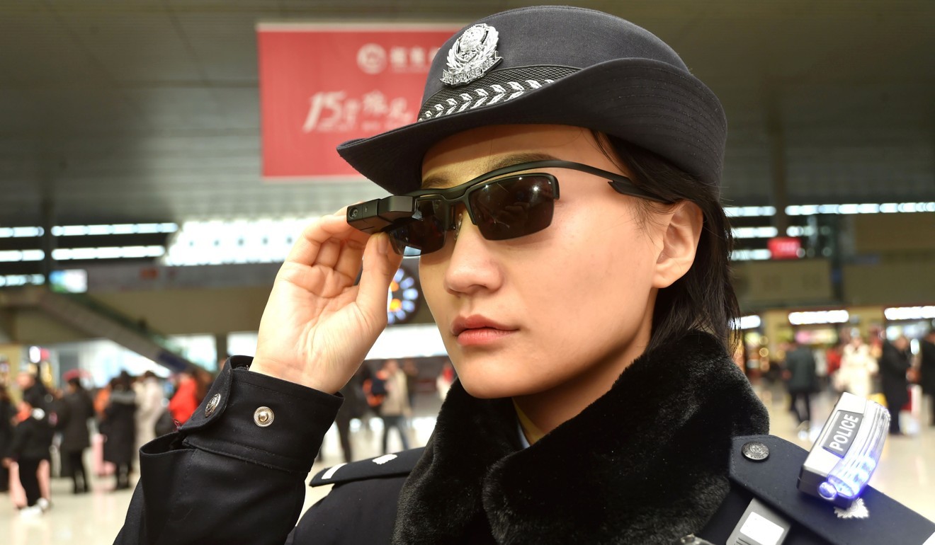 A police officer wearing smart glasses at Zhengzhou East Railway Station on February 5, 2018 / AFP PHOTO