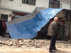 An old man walks past rubble and a collapsed metal sheet roof in Lushan County, near the epicentre of the Ya'an earthquake. Photo: SCMP/Simon Song