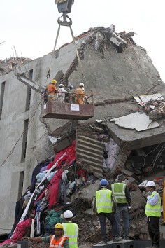 Search teams clear broken and crushed concrete slabs on Tuesday. Photo: AP