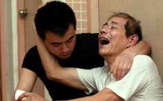 Sun Zhigang's father, Sun Liusong, is consoled by his son, Sun Ziguo. Photo: SCMP Pictures