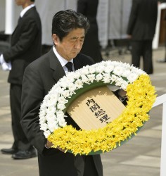 Japan's PM Shinzo Abe offers a flower wreath for victims of the atomic bombing. Photo: Reuters