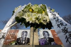 A wreath of flowers sits near his picture at the South African embassy in Beijing. Photo: AP