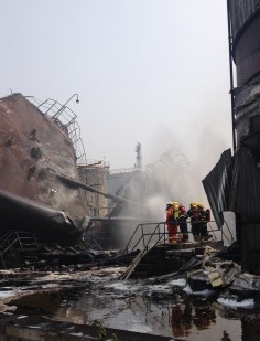 Firefighters inspect the damage after the oil refinery blast. Hours later, the flames surged again. Photo: Xinhua