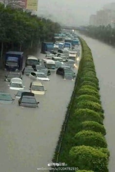 Vehicles are half-submerged on a flooded street in Haikou on July 18. Photo: Weibo