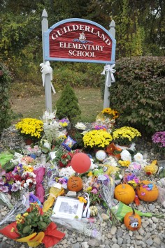 Flowers and other items are seen at the entrance to Guilderland Elementary School near the home of the family killed. Photo: AP