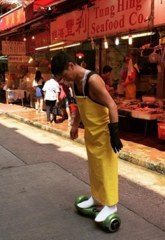 A man riding a hoverboard at a Causeway Bay wet market.