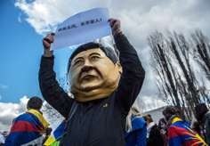 A protester wears a mask of President Xi Jinping during a rally in Prague. Photo: EPA