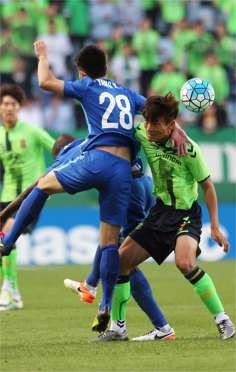 South Korea’s Jeonbuk Hyundai Motors midfielder Han Kyo-won (right) fights for the ball with China’s Jiangsu FC midfielder Yang Xiaotion in their group E game. Photo: AFP