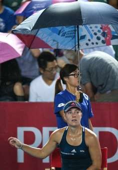 Angelique Kerber is given shelter from the rain. Photo: K.Y. Cheng