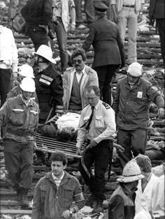 Rescue services carry out a dead man after the crush at Heysel Stadium during the European Cup final between Liverpool and Juventus. Photo: EPA