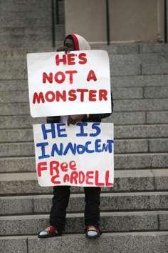 A supporter of Cardell Hayes holds signs outside Orleans Parish Criminal District Court. Photo: AP