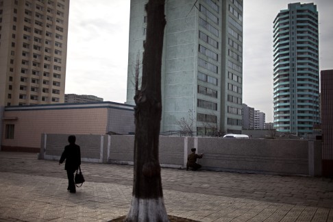  A soldier paints a wall as a woman walks past in Pyongyang, North Korea. Photo: AP