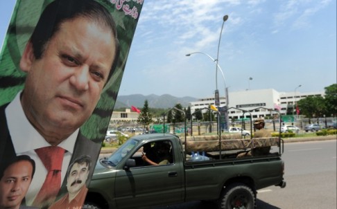 An army vehicle drives past a poster of Pakistan's Premier-elect Nawaz Sharif near parliament in Islamabad. Photo: AFP