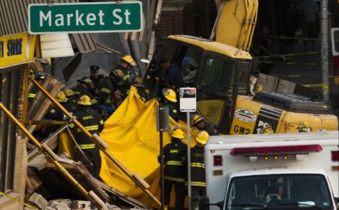 Firefighters search through rubble for body following a building collapse in Philadelphia. Photo: Reuters
