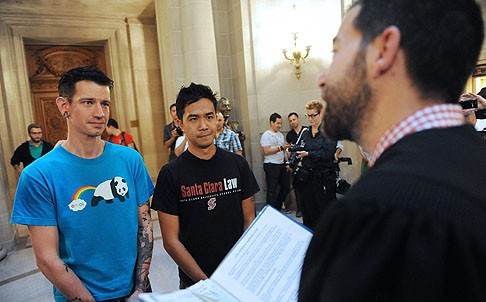 Jae (left) and Rob Keitamo are married by Jared Scherer at San Francisco City Hall. Photo: EPA