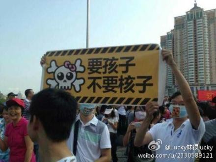 Demonstrators holding a banner saying "[We] want children, not atoms." Screenshot from Sina Weibo. 
