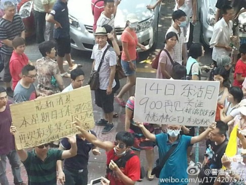 Demonstrators in Jiangmen on Friday morning holding banners calling for another protest on Sunday. Screenshot from Sina Weibo. 