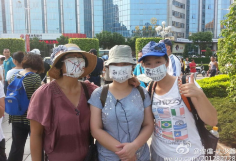 Three demonstrators near the Jiangmen municipal government building, seen earlier on Friday. Screenshot from Sina Weibo. 