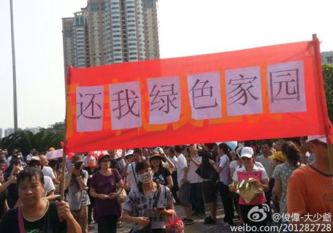 Demonstrators seen carrying a banner saying "Give me back a green home". Screenshot from Sina Weibo.  