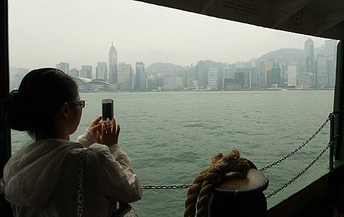 A tourist takes a hazy photograph of the Hong Kong skyline on Thursday. Photo: Edward Wong
