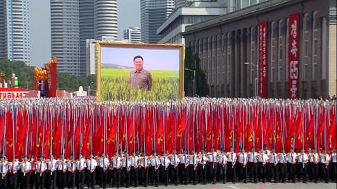 North Koreans carry North Korean flags while walking with a portrait of their late leader Kim Jong Il. Photo: AP