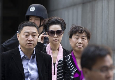 Celebrity singer Meng Ge, centre, adjusts her sunglasses as she leaves the Haidian District People's Court after attending her son's verdict, in Beijing on Sept. 26, 2013. Photo: AP