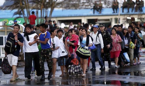 Filipino survivors walk towards a military aircraft as they prepare to leave Tacloban for Manila on Tuesday. Photo: EPA