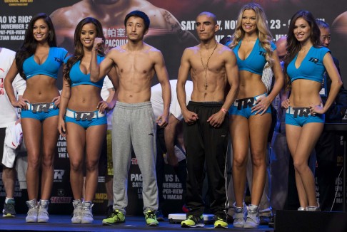 China's Zou Shiming, two-time Olympic Games gold medallist and three-time World Amateur Champion, poses with Mexico's Toscano during official weigh-in ahead of their match. Photo: Reuters