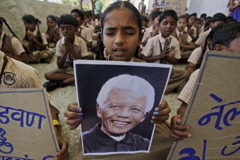 An Indian schoolgirl holds a portrait of Nelson Mandela. Photo: AP 