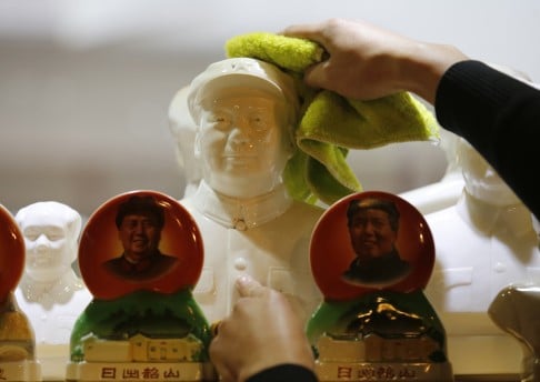 An assistant dusts off a bust of Chairman Mao at an antique shop in Beijing. Photo: Reuters