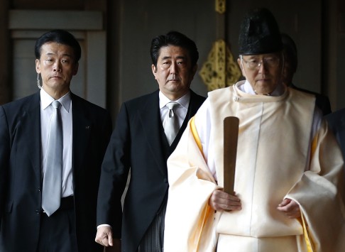 Japan's PM Abe being led by a Shinto priest as he visits Yasukuni shrine in Tokyo on December 26, 2013. Photo: Reuters
