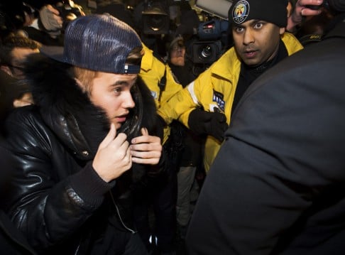 Canadian musician Justin Bieber was swarmed by media and police officers as he turned himself into city police for an expected assault charge on Wednesday Photo: AP