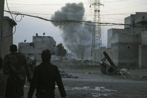 Smoke rises while Free Syrian Army fighters stand at the Karm al-Tarab neighborhood frontline in Aleppo. Photo: Reuters