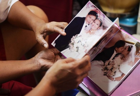 Marrz Balaoro (left) and her partner Irene Coles Peji look at pictures from their wedding album. Photo: AFP