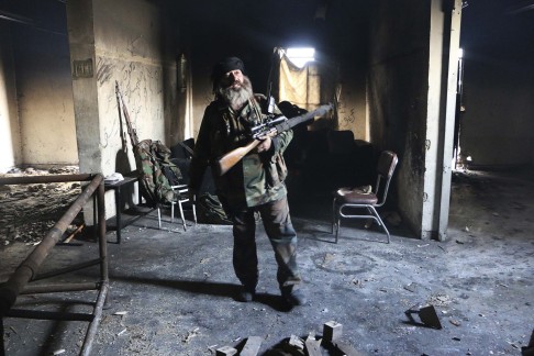 A Free Syrian Army fighter stands inside a damaged building in Aleppo's Sheikh Maqsoud neighbourhood. Photo: Reuters