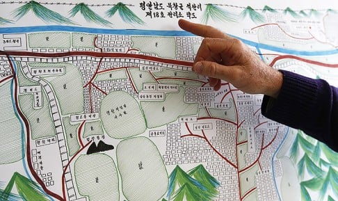  A UN Human Rights staff member points to the title of a drawing describing North Korean labour camp no 18 in Geneva. Photo: Reuters