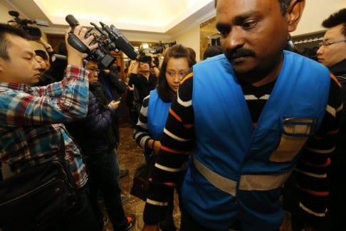 Members of a Special Assistance Team from Malaysia (wearing blue vests) arrive at a hotel where relatives of passengers of a missing Malaysia Airlines plane are meeting in Beijing, China. Photo: EPA