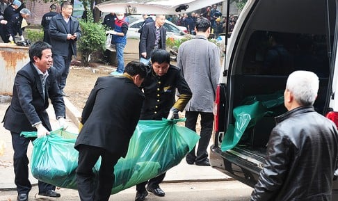 Investigators move a victim's body into a van as they work at the scene where attackers armed with knives killed three people in Changsha. Photo: AFP