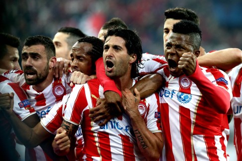 Olympiakos' Argentinian midfielder Alejandro Dominguez (centre) celebrates with teammates after scoring in the first leg. Photo:A FP