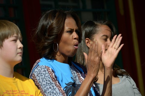 US First Lady Michelle Obama, centre, applauds as she watches a performance of the Beijing Opera with her daughter Malia, right, at the Summer Palace in Beijing. Photo: AFP